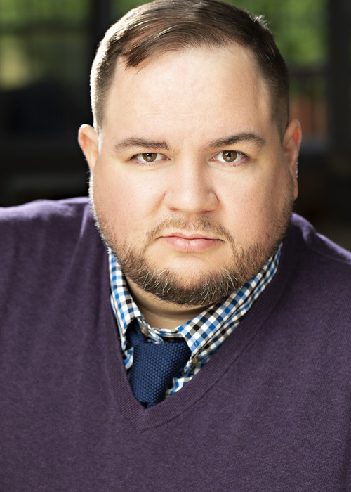 Serious, purple sweater and tie
